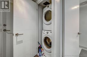 Toronto (Waterfront Communities) condo for rent - A white washing machine is in a small laundry room.