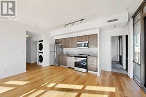Toronto (Bay Street Corridor) condo for rent - A modern kitchen with wooden floors and stainless steel appliances.