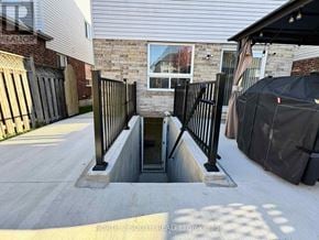 Whitby (Williamsburg) apartment for rent - A concrete staircase with a metal railing leads down to a basement entrance.