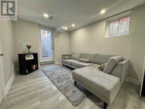 Whitby (Williamsburg) apartment for rent - A living room with a grey couch and a grey rug.