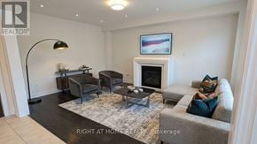 East Gwillimbury (Queensville) apartment for rent - A living room with a grey couch, a black floor lamp, and a fireplace.