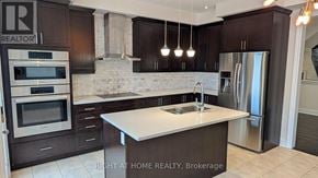 East Gwillimbury (Queensville) apartment for rent - A modern kitchen with dark brown cabinets and stainless steel appliances.