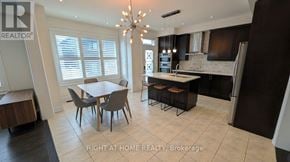 East Gwillimbury (Queensville) apartment for rent - A well-lit kitchen with a dining table and chairs.