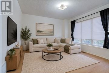 Markham (Berczy) townhouse for rent - A living room with a couch, a coffee table, and a painting on the wall.