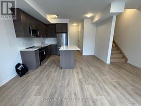 Newmarket (Glenway Estates) townhouse for rent - A kitchen with wooden flooring and a staircase in the background.