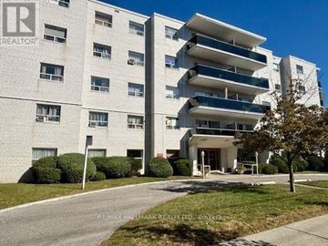 Mississauga (Cooksville) house for rent - A large white apartment building with a sign that says REALTOR.