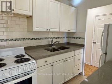 Mississauga (Cooksville) house for rent - A kitchen with white cabinets and a white stove top oven.