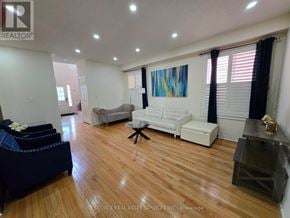 Milton (Ha Harrison) apartment for rent - A living room with a white couch and a blue ottoman.
