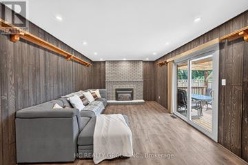 Hamilton (Freelton) apartment for rent - A modern living room with a grey sofa and a fireplace.