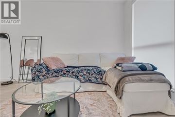Waterloo condo for rent - A modern living room with a white sofa and a glass coffee table.
