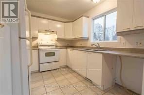 South Glengarry apartment for rent - A kitchen with white cabinets and a stove top oven.