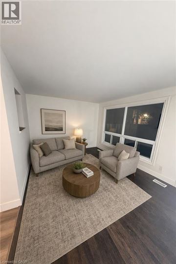 Cambridge townhouse for rent - A living room with a grey couch, a brown coffee table, and a painting on the wall.