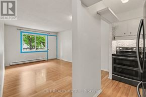 Ottawa condo for rent - A room with a wooden floor and a large window with a view of trees.