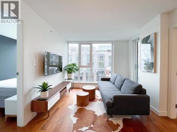 Vancouver apartment for rent - A living room with a grey couch and a cowhide rug.