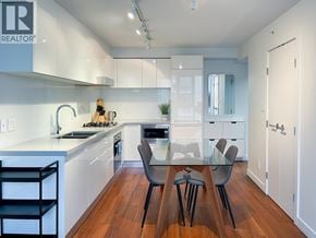 Vancouver apartment for rent - A modern kitchen with white cabinets and a wooden floor.