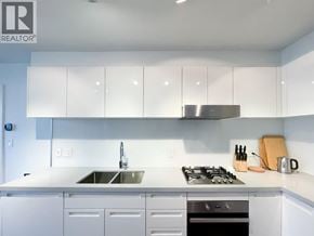 Vancouver apartment for rent - A modern kitchen with white cabinets and stainless steel appliances.