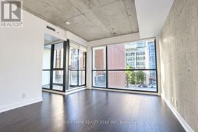 Toronto (Waterfront Communities) condo for rent - A spacious room with a view of the city through large windows.
