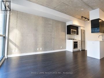 Toronto (Waterfront Communities) condo for rent - A spacious kitchen with white cabinets and a microwave above the oven.
