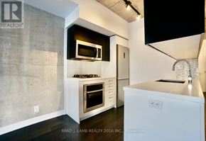 Toronto (Waterfront Communities) condo for rent - A modern kitchen with a white countertop and stainless steel appliances.