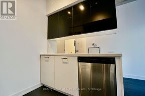 Toronto (Waterfront Communities) condo for rent - A kitchen area with a stainless steel dishwasher and white cabinets.