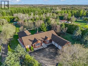 Milton apartment for rent - A large house with a brown roof is surrounded by trees.
