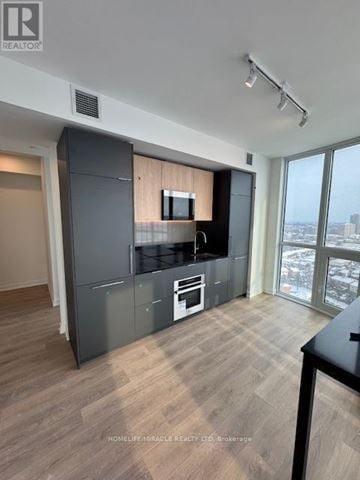 Mississauga (Mississauga Valleys) house for rent - A modern kitchen with a large island and a view of the city.
