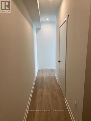 Mississauga (Mississauga Valleys) house for rent - A long hallway with wood floors and white walls.