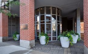 Toronto (Moss Park) condo for rent - The front of a building with a glass door and a sign that says "235 N. 1st St."