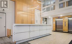 Toronto (Moss Park) condo for rent - A white reception desk with a wooden door and a glass wall in the background.