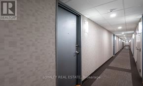Toronto (Moss Park) condo for rent - A hallway with a blue door and a sign that says "Loyalty Real Estate Brokerage".