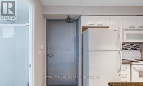 Toronto (Moss Park) condo for rent - A white refrigerator is in a kitchen with a door open.