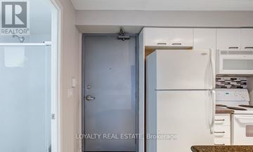 Toronto (Moss Park) condo for rent - A white refrigerator is in a kitchen with a door open.