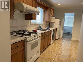 Burnaby apartment for rent - A kitchen with a white stove top oven and a white refrigerator.