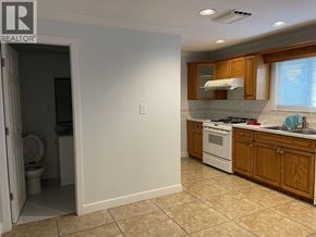 Burnaby apartment for rent - A kitchen with a white stove and wooden cabinets.