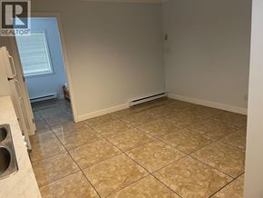 Burnaby apartment for rent - A room with beige tiled flooring and white walls.