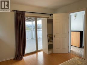 Burnaby apartment for rent - A room with a sliding glass door and a brown curtain.
