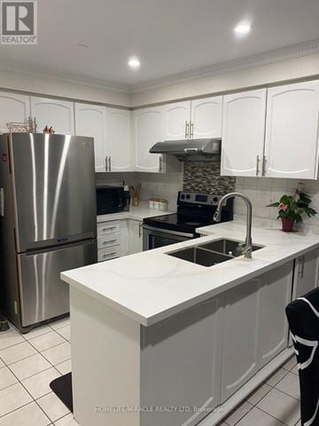 Brampton (Sandringham-Wellington) townhouse for rent - A kitchen with white cabinets and a stainless steel refrigerator.