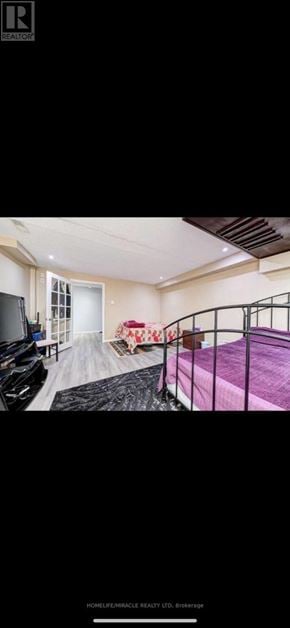 Brampton (Sandringham-Wellington) townhouse for rent - A bedroom with a bed, a couch, and a television.