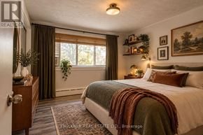 Ottawa multi-family for rent - A bedroom with a large bed and a window with curtains.