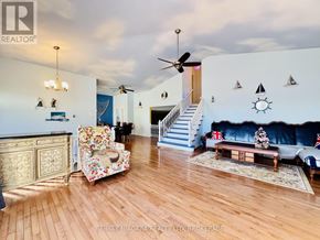 Fort Erie (Central) apartment for rent - A living room with a sofa, armchair, and staircase.