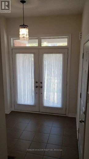 Markham (Greensborough) townhouse for rent - A white door with a glass panel and a chandelier hanging from the ceiling.
