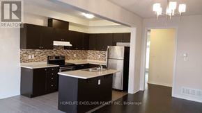 Markham (Greensborough) townhouse for rent - A modern kitchen with a stone backsplash and dark cabinets.