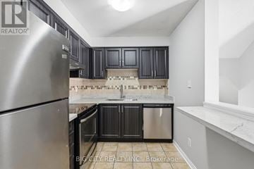 Pickering (Town Centre) townhouse for rent - A kitchen with a stainless steel refrigerator and black cabinets.