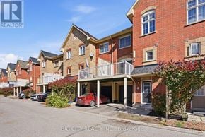 Pickering (Town Centre) townhouse for rent - A red car is parked in front of a brick building.