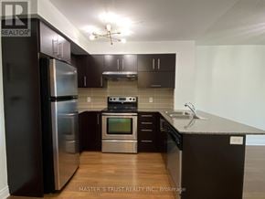 Markham (Commerce Valley) condo for rent - A kitchen with dark brown cabinets and stainless steel appliances.