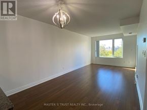 Markham (Commerce Valley) condo for rent - A room with wooden floors and a window letting in light.