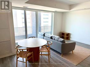Markham (Unionville) condo for rent - A living room with a grey couch, a round wooden table, and a rug.