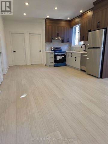 Toronto (Bendale) multi-family for rent - A kitchen with wooden cabinets and a refrigerator.