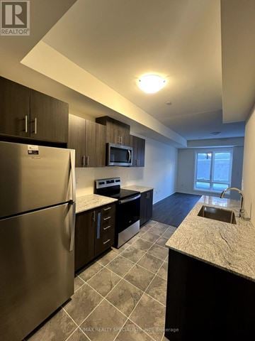 Toronto (Malvern) townhouse for rent - A kitchen with a stainless steel refrigerator and a granite countertop.