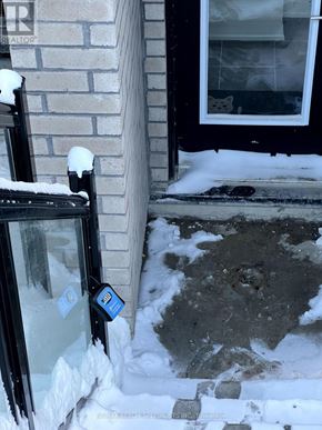 Toronto (Malvern) townhouse for rent - A snow-covered ground with a black door and a window.